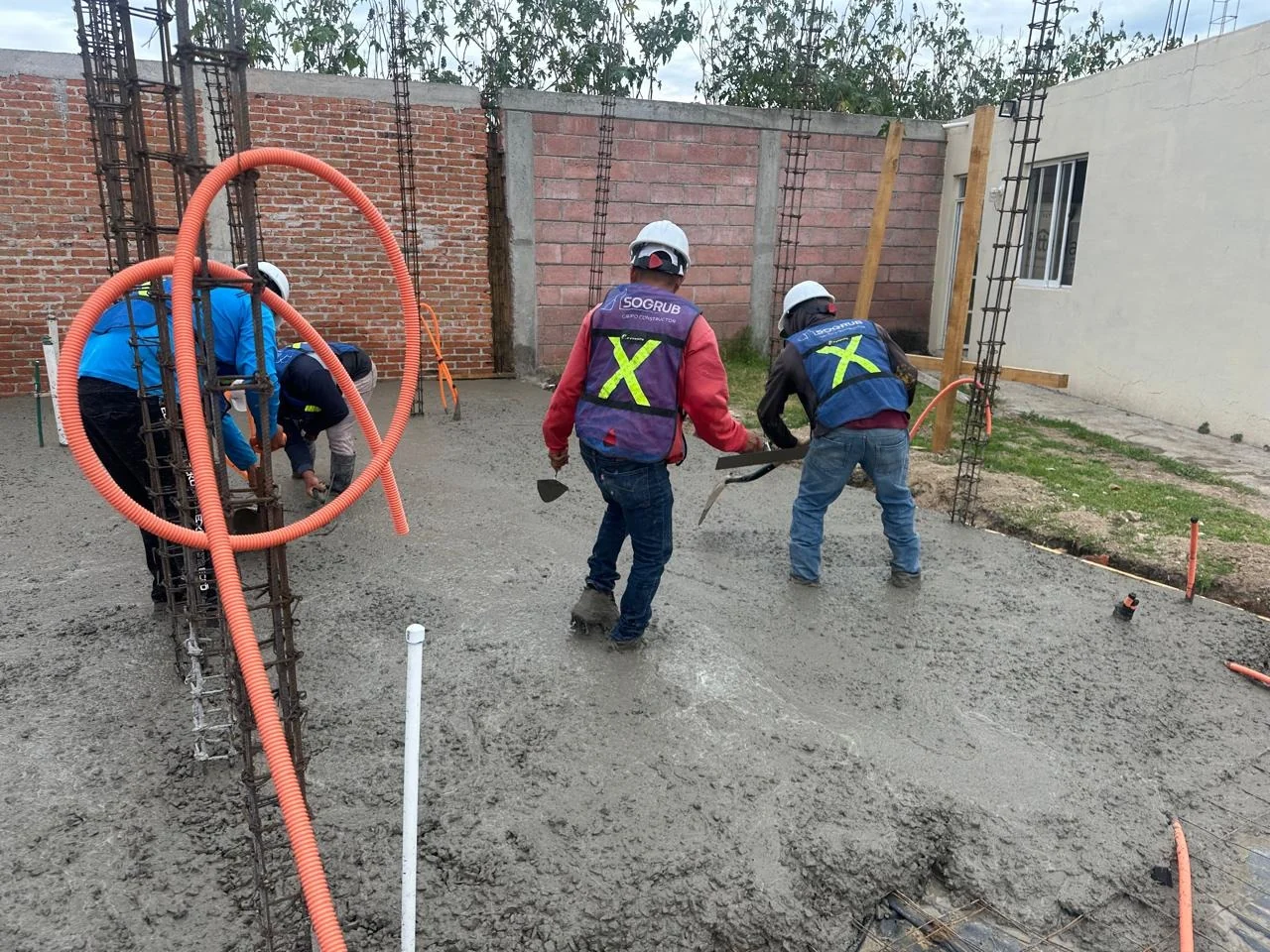 Cuadrilla de SOGRUB tendiendo concreto en un firme
